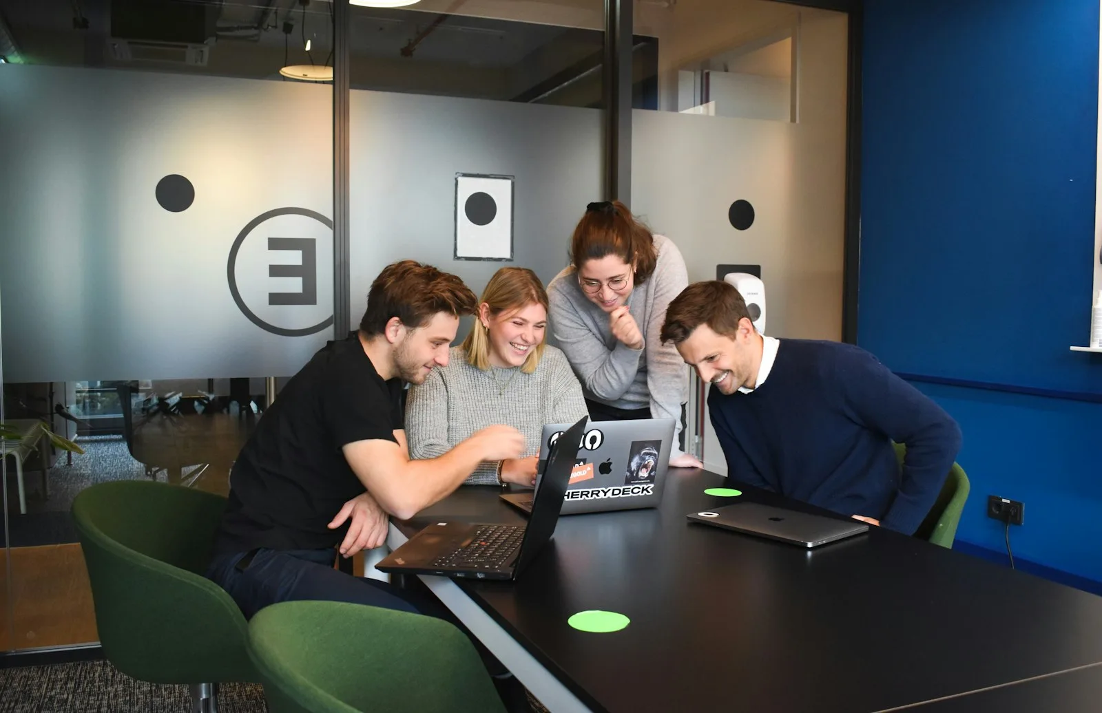 Team collaborating around a laptop in an office